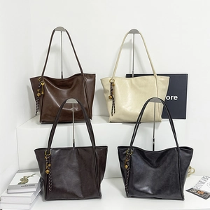 Primer plano de cuatro bolsos tote grandes en tonos marrón, beige, café y negro