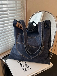 Large dark blue denim tote bag with leather logo patch and double shoulder straps for women