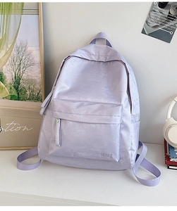 Macro detail of lavender backpack with subtle floral jacquard fabric and brand logo