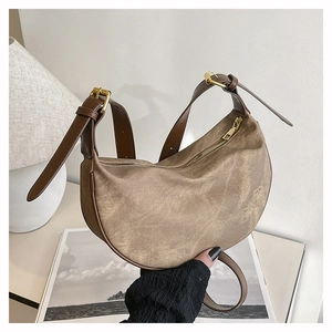Macro detail of retro brown canvas moon bag with leather trim and adjustable strap