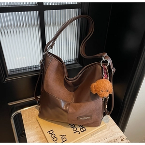 Detail of vintage patchwork hobo bag in dark brown glossy leather and matte suede finish