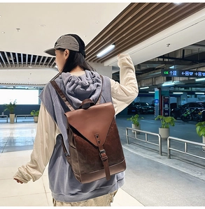 Detail eines dunkelbraunen Lederrucksacks mit Metallschnalle und sauberen Nähten
