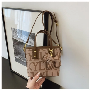 Detail der khakifarbenen Canvas-Tasche mit LUCKY-Jacquardmuster und Lederriemen