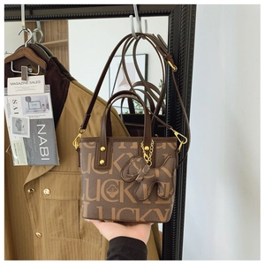 Detailansicht der dunkelbraunen Beuteltasche mit Lucky-Print und Hundeanhänger