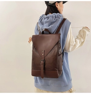 Detail eines dunkelbraunen Lederrucksacks mit Vintage-Schnallen und praktischer Seitentasche
