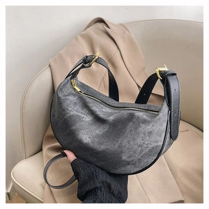 Detailed shot of dark grey washed denim hobo bag with black leather strap and gold hardware