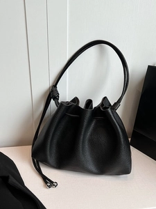 Minimalist black drawstring pleated bucket bag with lychee texture and slim shoulder strap