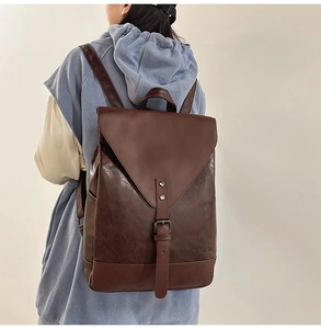 Detailansicht eines dunkelbraunen Vintage-Lederrucksacks mit Schnalle und Logo-Prägung