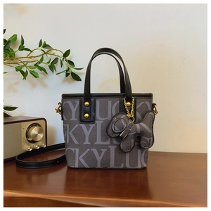 Detail der grauen LUCKY Print Beuteltasche mit Hundeanhänger und goldener Hardware