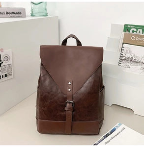 Detailansicht des braunen Vintage-Lederrucksacks mit Silberschnallen und Seitentasche