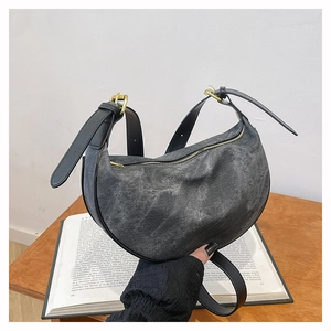 Close-up of black washed canvas hobo bag with adjustable leather strap and gold hardware
