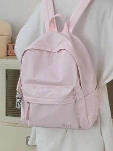 Minimalist light pink waterproof nylon backpack with a decorative silver bear pendant