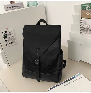 Detail eines schwarzen Vintage-Lederrucksacks mit Metallschnalle und strukturierter Klappe
