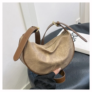 Detail of vintage washed canvas crescent bag with brown leather trim and metal buckles