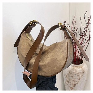 Detail of hobo crossbody bag with brown canvas texture and adjustable leather strap