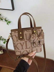 LUCKY Print Beuteltasche Damen mit Lederbesatz und Hundekopf-Anhänger auf Holztisch