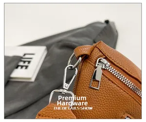 Macro view of caramel brown lychee leather texture and silver metal zipper on saddle bag