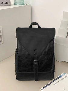 Vintage schwarzer Lederrucksack mit V-Klappe und Metallschnalle im modernen Büro-Ambiente
