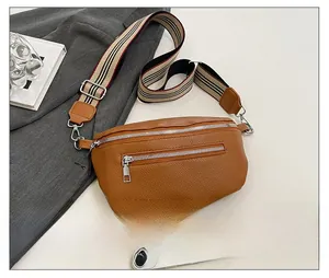Brown litchi grain leather saddle bag with striped strap and dual silver zippers