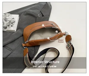 Detailed view of brown lychee leather bag with striped strap and front zip pocket