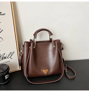 Vue détaillée du sac seau en cuir marron foncé avec élégantes garnitures dorées