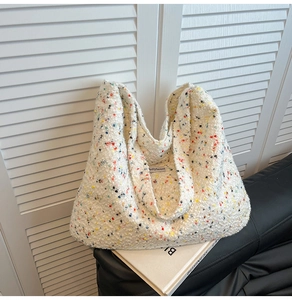 Große cremefarbene Tragetasche mit bunten Sprenkeln und strukturierter Tweed-Optik im Detail