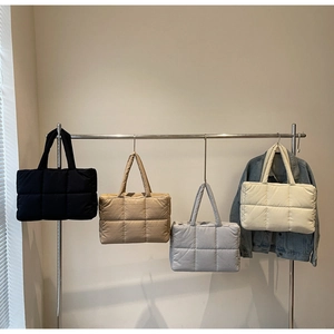 Detailed view of four quilted puffer tote bags in black, khaki, grey, and cream colors
