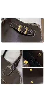 Detail view of coffee brown leather tote featuring gold buckles and white contrast stitching