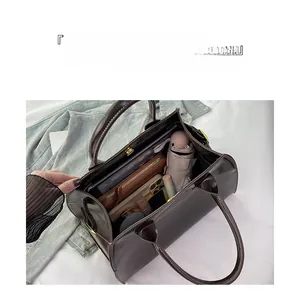 Spacious interior of brown leather tote bag showing storage for tablet and umbrella