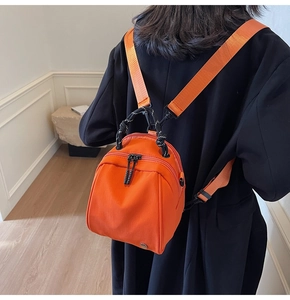 Detail van de feloranje nylon rugzak met geweven handvat en verstelbare schouderbanden