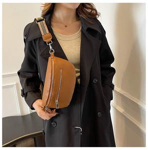 Detail of brown litchi leather saddle bag with distinctive striped shoulder strap