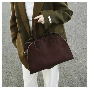 Detail of dark brown suede tote bag with double handles in a vintage commuting style