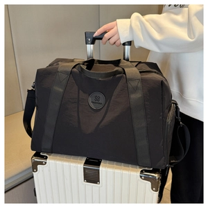 Black travel bag on suitcase handle showing the convenient trolley sleeve feature