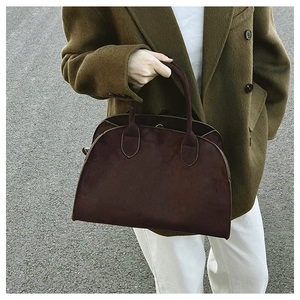 Street style shot of a vintage burgundy suede tote bag paired with a brown wool coat