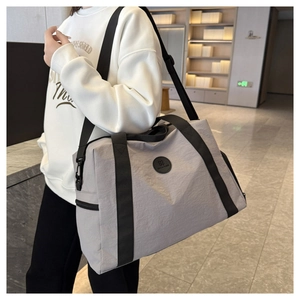 Large gray oxford travel bag with adjustable strap and waterproof texture shown on model