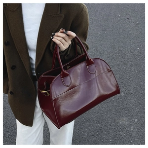 Close-up of wine red leather tote bag with white contrast stitching for daily commute