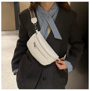 Detail of white lychee leather chest bag with striped strap and dual silver zippers