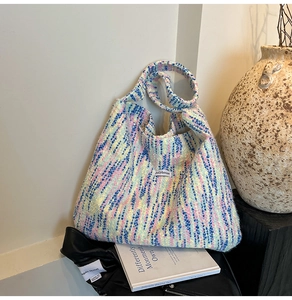 Nahaufnahme der bunten Tweed-Webstruktur und Jellyhouse-Markenlabel auf einer Hobo-Tasche
