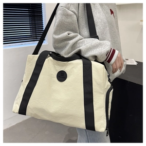 Detail of large capacity Oxford travel bag with black straps and side zipper pocket