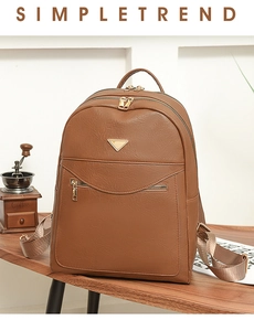 Detail of brown faux leather backpack featuring pebbled texture and metal zipper