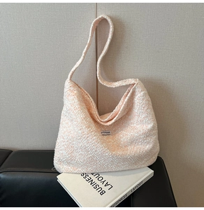 Nahaufnahme der rosa-weißen Tweed-Hobo-Tasche mit Schultergurt und Logo-Etikett