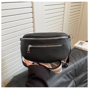 Detail of black lychee grain leather saddle bag with striped strap and silver hardware