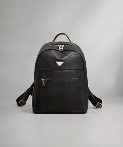 Detail shot of the golden triangular metal hardware on black lychee grain leather backpack