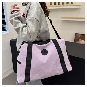 Large capacity lavender oxford travel bag with adjustable black shoulder strap shown on model