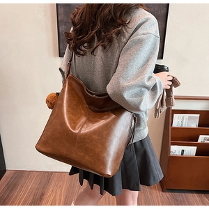 Détail du grand sac cabas marron vintage avec bandoulière réglable et pendentif ours