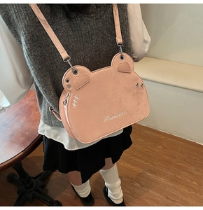 Close-up of pink bear-shaped crossbody bag with Princess embroidery and silver hardware