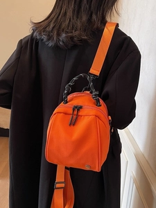 Mini oranje rugzak en crossbodytas met een stijlvol gevlochten bovenhandvat