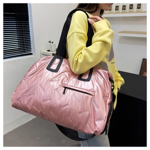 Close-up of pink quilted travel bag with metallic finish and wide shoulder strap