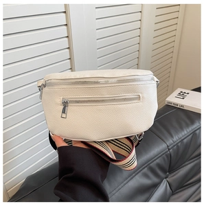 Close-up of white pebble leather saddle bag with tricolor striped woven shoulder strap