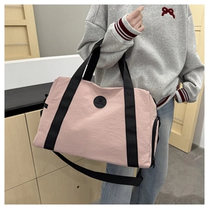 Detail of pink lightweight oxford cloth travel bag with shoe compartment and woven handles